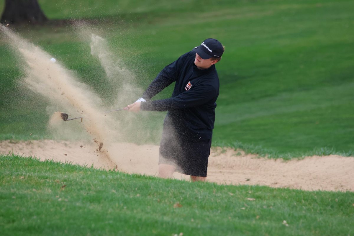 Freshman Sam Everson hits his ball out of the bunker
