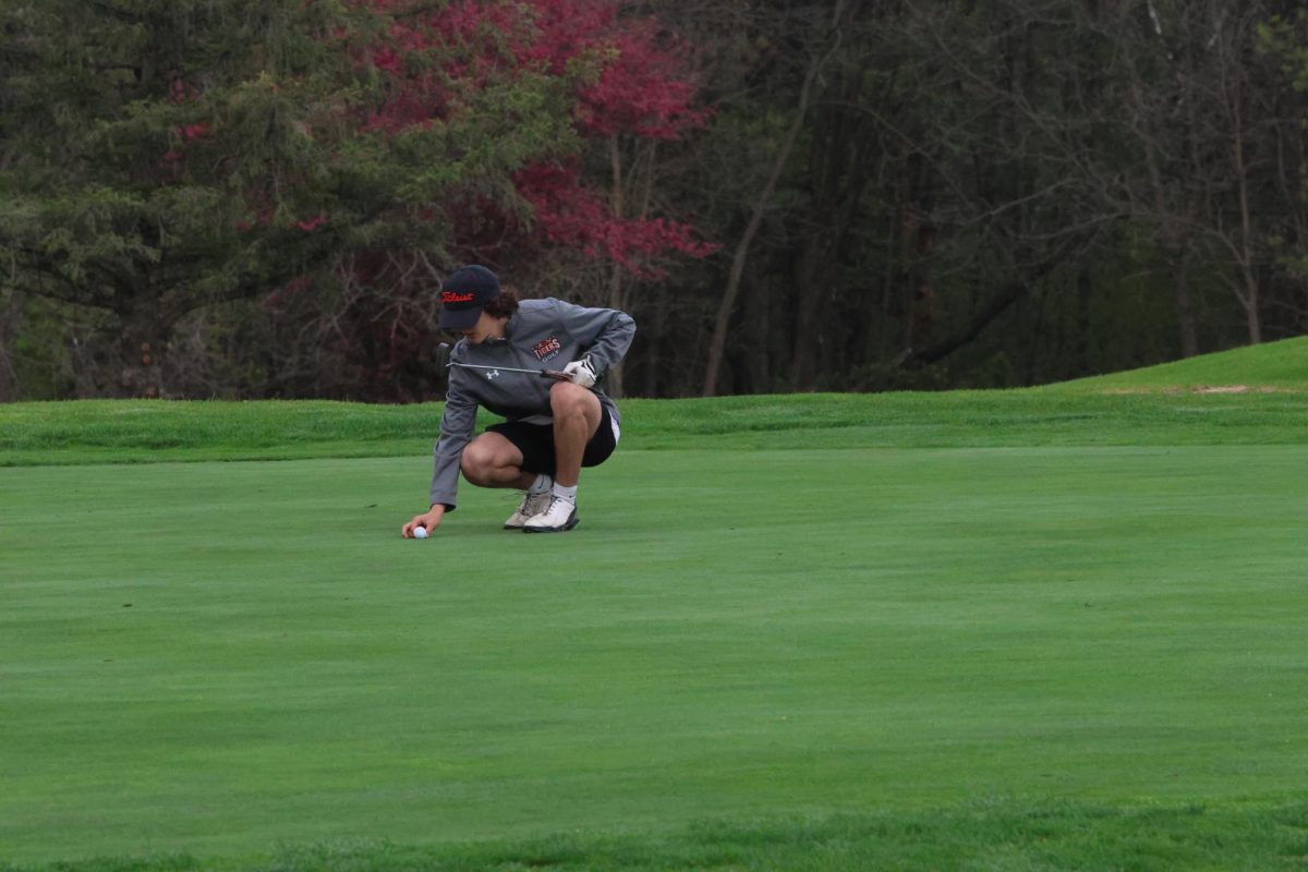 Sophomore Calvin Lakowske lines his ball up for the perfect putt.

